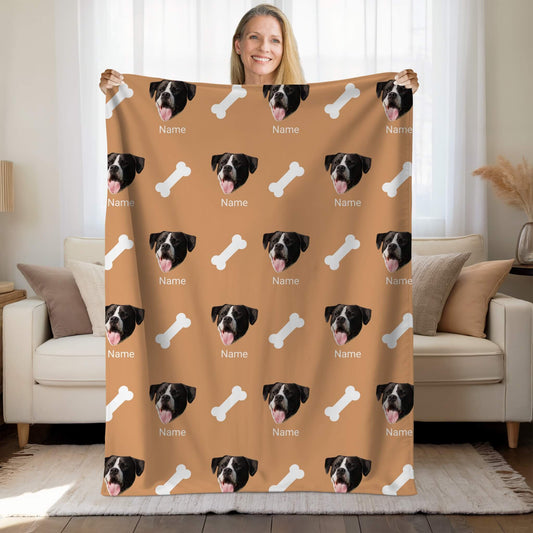 Person holding a custom blanket with dog faces and bones on a living room background
