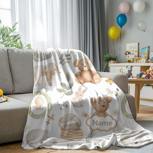 Children's room with a blanket featuring teddy bears and other animals draped over a chair.