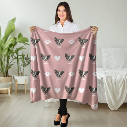 Woman holding a pink blanket with dog patterns in a room.