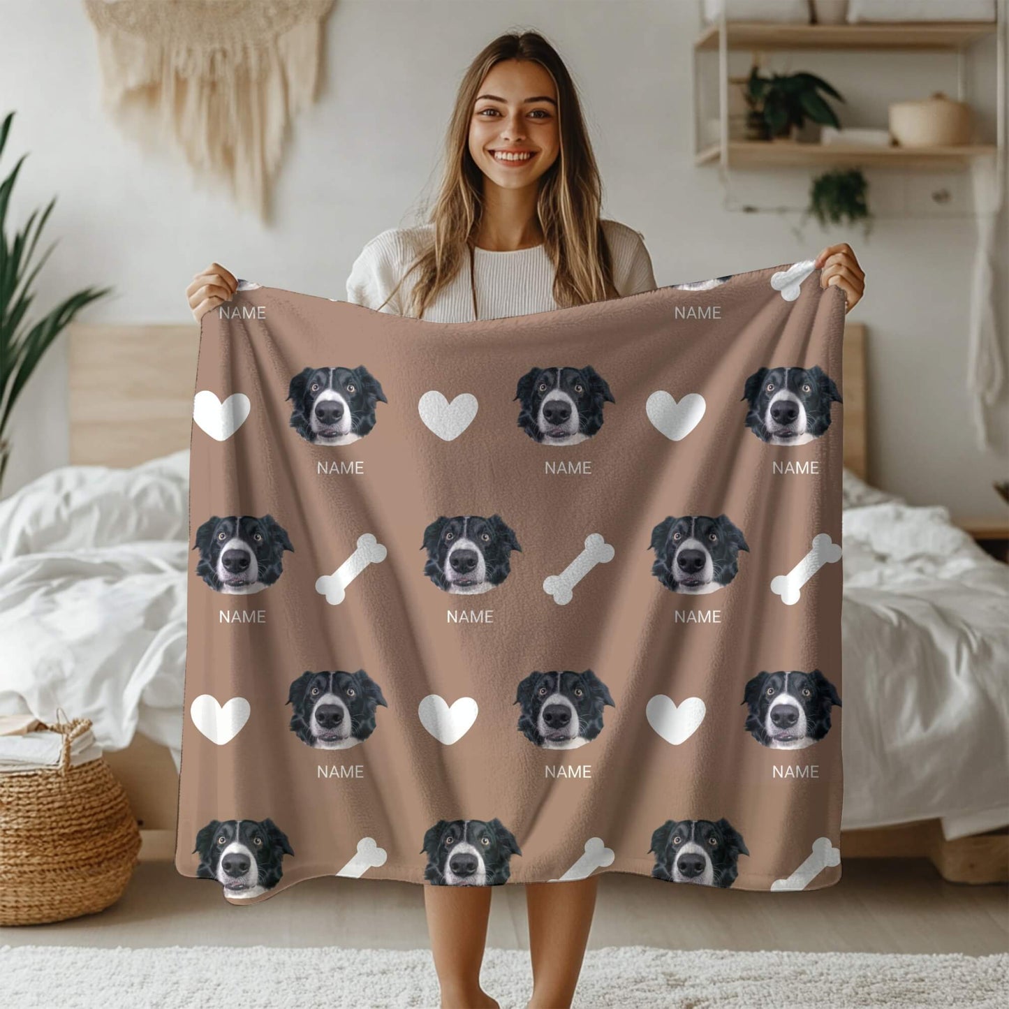 Woman holding a brown blanket with dog illustrations and text in a bedroom setting