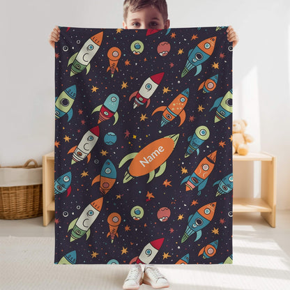 Child holding a colorful space-themed blanket with rockets and planets