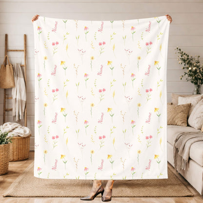 Floral patterned blanket with 'Name' text draped over a couch in a living room setting.